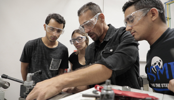 tres estudiantes con profesor