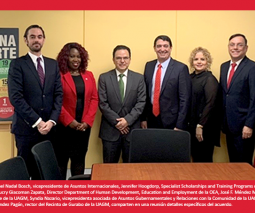 Foto del grupo ejecutivo de la Universidad parados detras de una mesa