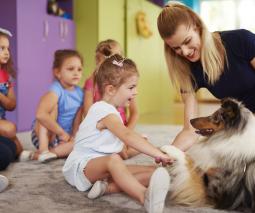 niños pequeños con perro y maestra 