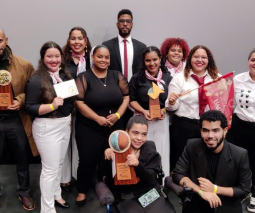 Profesor con estudiantes y el premio de Enactus