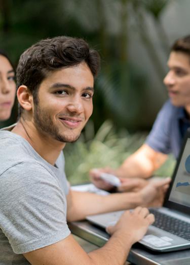 Grupo de estudiantes sentados en un banco en la universidad