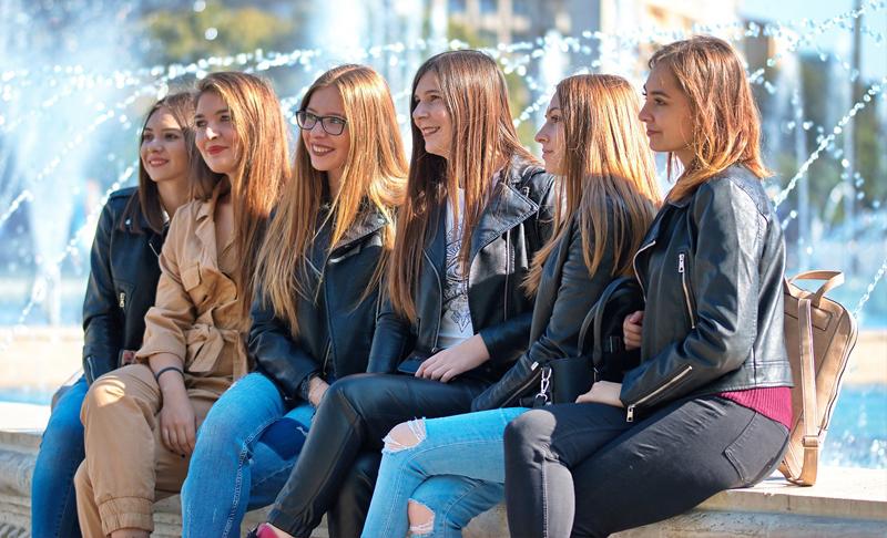 grupo de muchachas sentadas en una fuente de agua