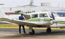 Avioneta blanca con dos rayas verdes y una amarilla